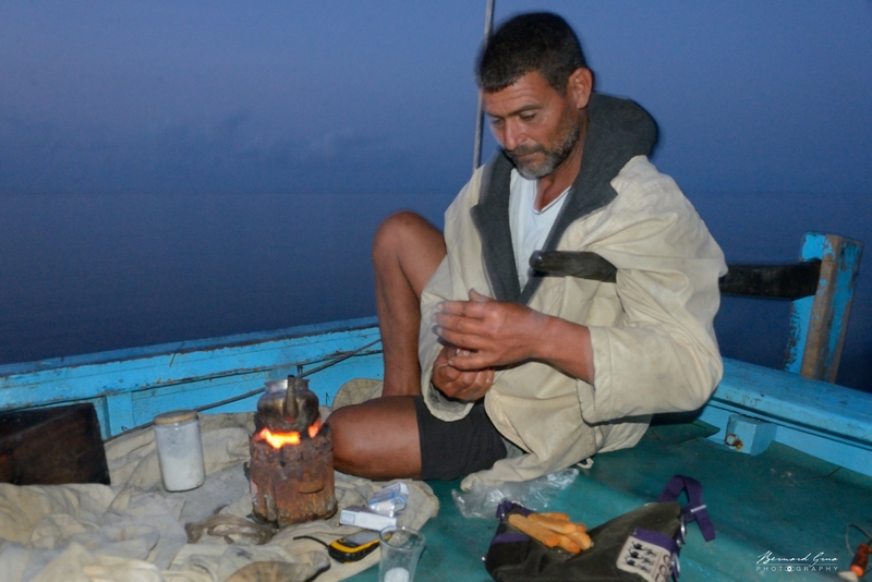 Il est 5:30 du matin ce vendredi 30/09/2016. Le pêcheur kerkennien Fathi Djebel d'El Attaya est en route depuis plus d'une heure sur sa felouque à moteur "in bord". Dès le départ, son premier geste a été d'alumer son canoun avec du charbon de bois sur lequel il préparera en permance un thé très sucré. Dans une heure et demi, il sera sur les lieux où il a mouillé ses centaines de "drinas" (nasses) pour piéger le poulpe. Le ciel est constellé d'étoile mais une brume basse mouille le bateau. Fathi n'a pas de carte, pas de compas de route. Pour l'instant il fait cap plein Est. Il retrouvera ses pièges grace à un petit GPS de voiture. Son diesel le propulse à une vitesse de ... 8 km/h. Quatorze ans ont passé. Les magnifiques felouqes ne glissent plus en silence sous leurs élégantes voiles latines. A Kerkennah, un des ultimes sanctuaires de la voile au travail est fracassé. Pour l'instant les charpentiers navals tels continuent à construire des merveilles. Pour combien de temps?
